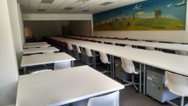 Photo of interior of wholesale vehicle dealer license location showing long rows of empty desks