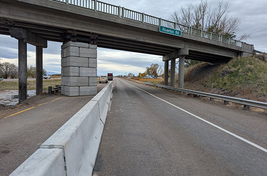 right hand lane of I-15 is open with a concrete divider protecting temporary pier supporting bridge.