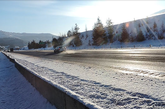 A car loses snow from its roof as it drives over the dip on I-90 near Kellogg.