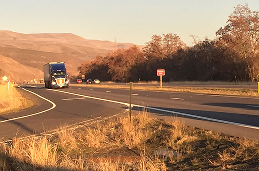 A semi passes the east entrance to Aht