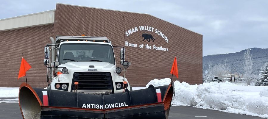 Snowplow positioned outside a school with the name "Antisnowcial" on the blade.